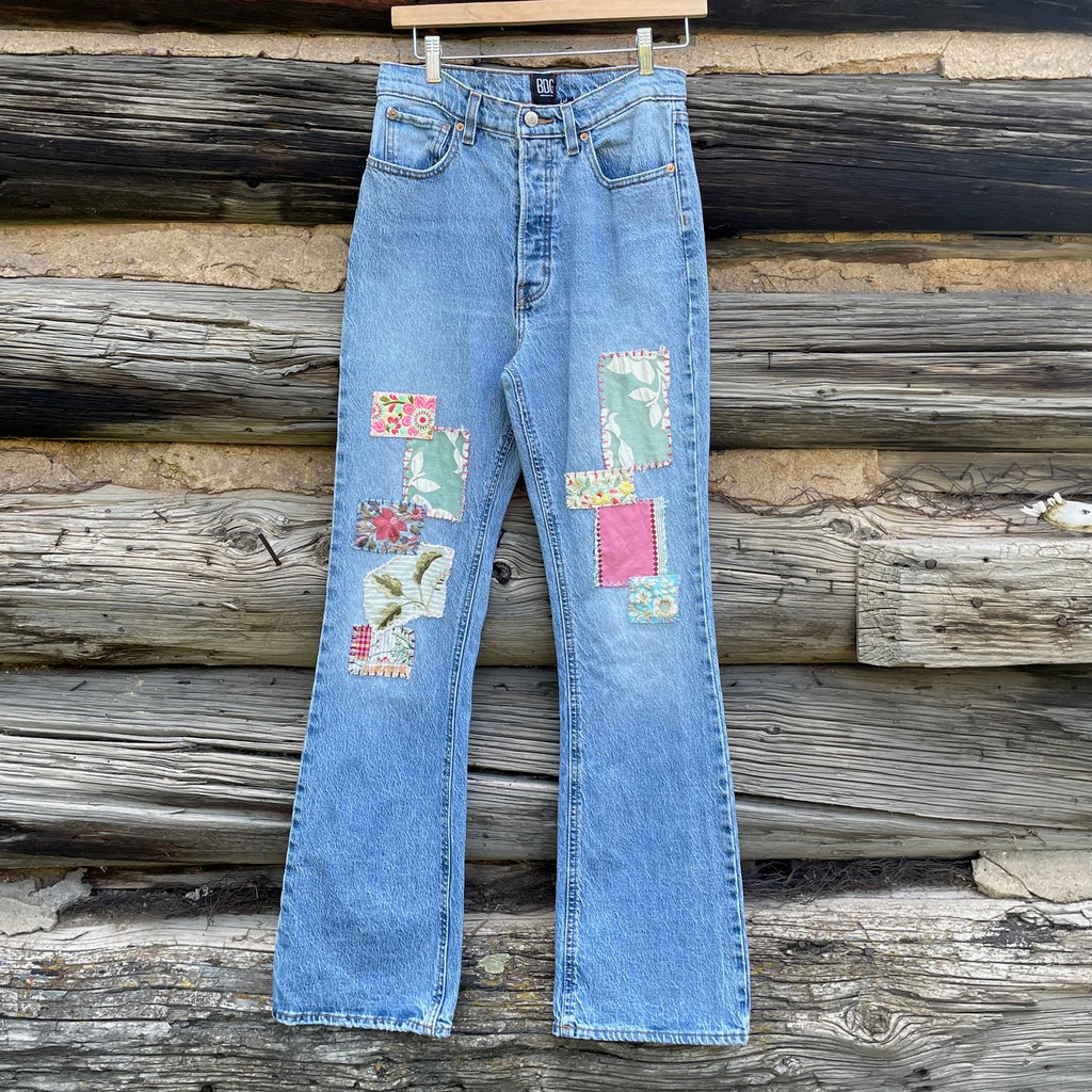 Front of jeans with colorful sewn on patches.