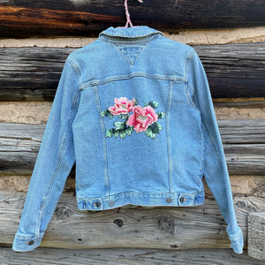 Back of jean jacket with centered rose patch.