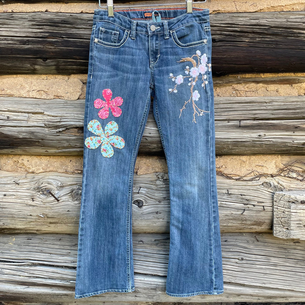 Front of Patchwork jeans with hand embroidered flower patches and flowered branch