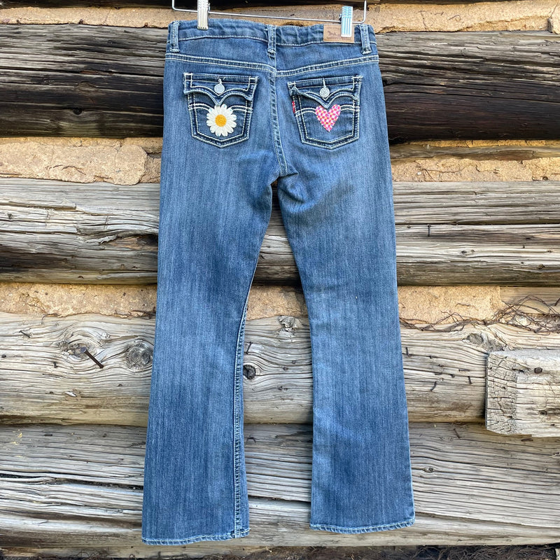 Back of patchwork jeans with flower and heart patches on back pockets.