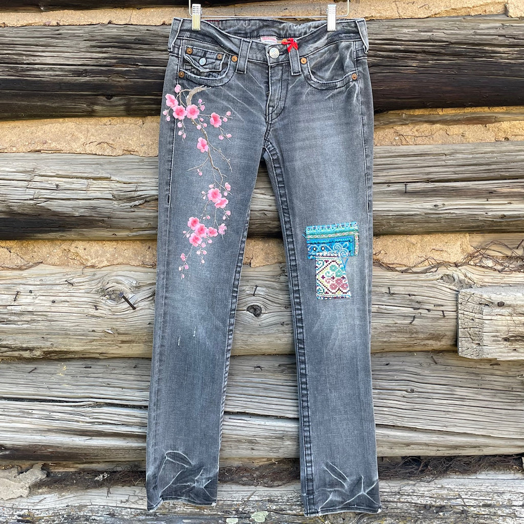 Front of Patch jeans with embroidered fabric patches.