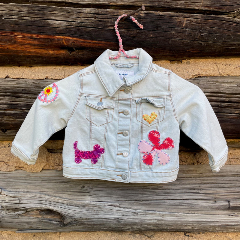 Front of light wash denim jacket with flower patches