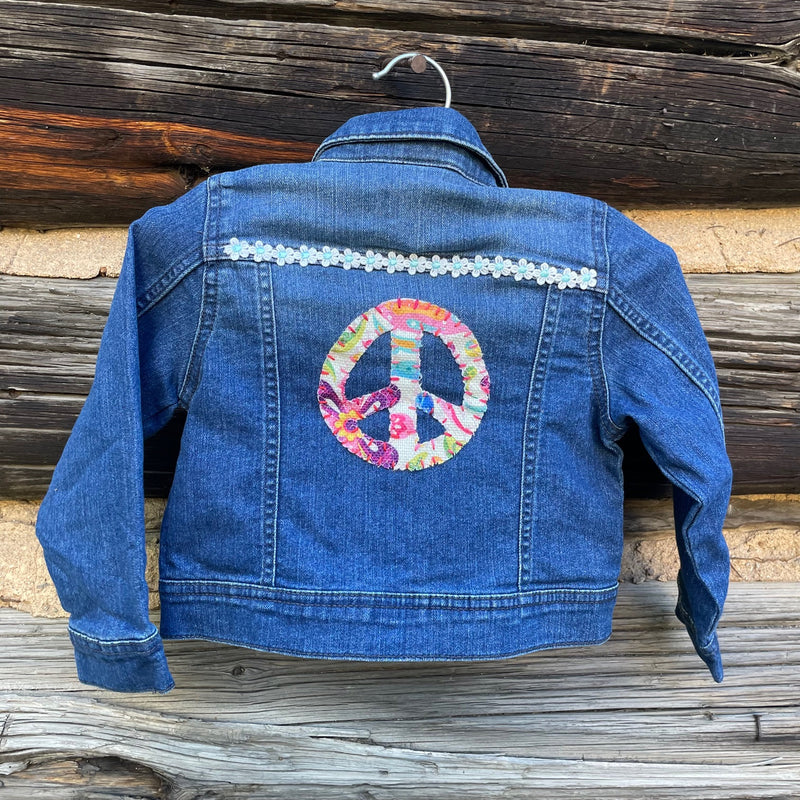 Back of jean jacket with peace sign patch.