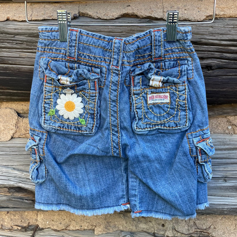 Back of jean shorts with flower patch.