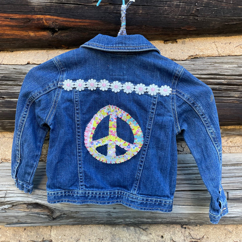 Back of jean jacket with peace sign patch.