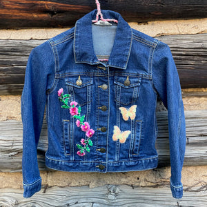 Front of jean jacket with flower and butterfly patches.