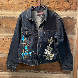 Denim jacket with floral embroidery on a wooden background