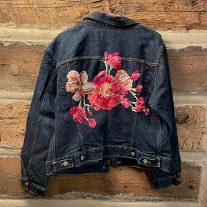 Denim jacket with floral embroidery on a wooden background