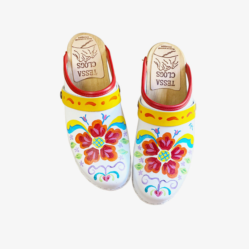 White leather on our traditional heel with natural stain, our hand painted Petra design, a red edgeband, and yellow with orange scroll straps.