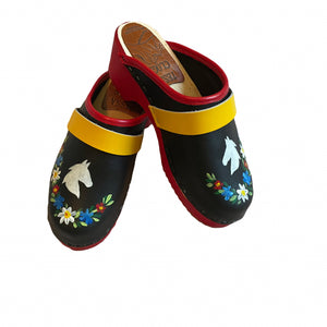 Pair of black clogs with red and yellow accents and floral designs on a white background