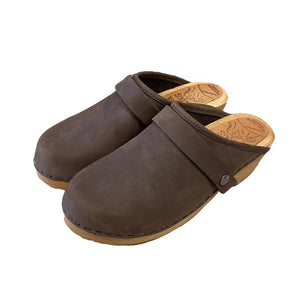 A pair of dark brown leather clogs with  straps and light tan soles, shown on a plain white background.