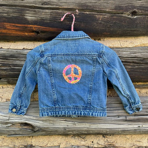 Back of jean jacket with one large peace sign patch.