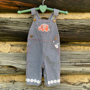 Striped overalls with a pink elephant patch and pink flower and daisy cuff.