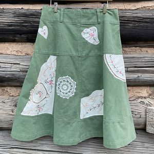 Back of green denim skirt with vintage napkin patches.