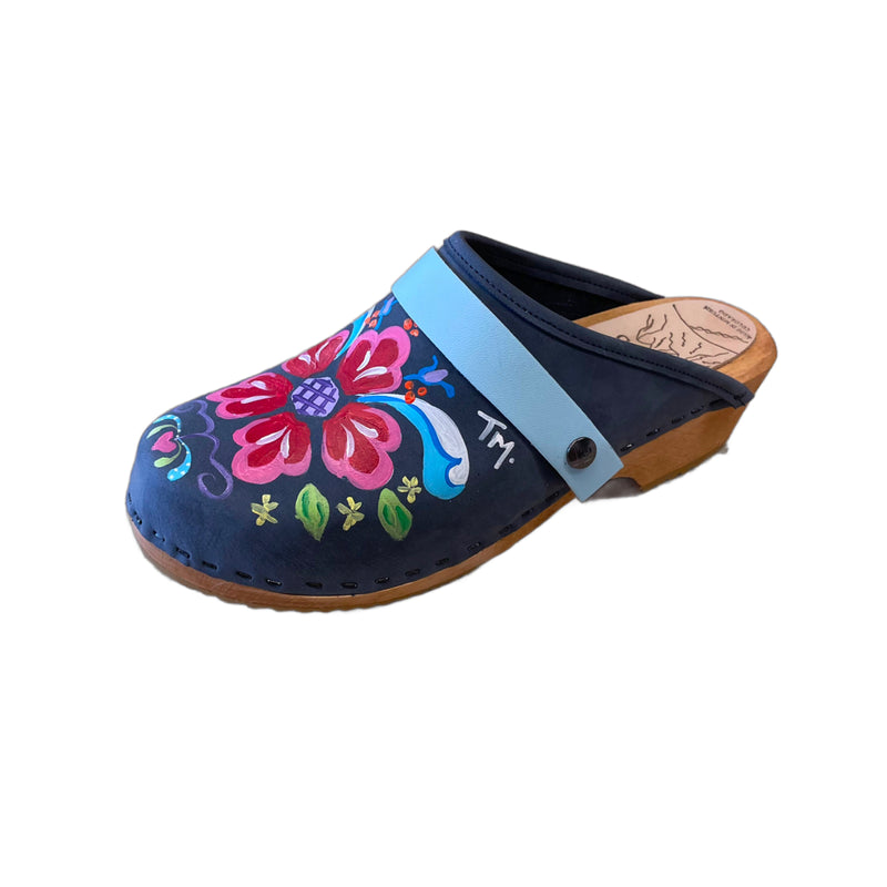 Traditional heel Tessa clog in denim blue leather and natural wood stained soles with the hand painted Petra design and a plain baby blue snap strap.