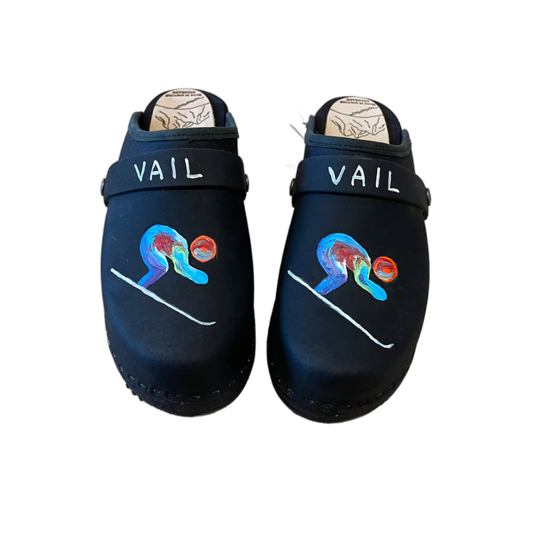Traditional heel clog in black leather and black stained soles, with our special edition world championship hand painted design on each shoe. Shown with a black VAIL painted snap strap.