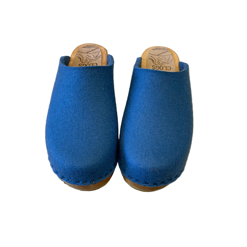 blue felt wool clogs on wooden sole and white background