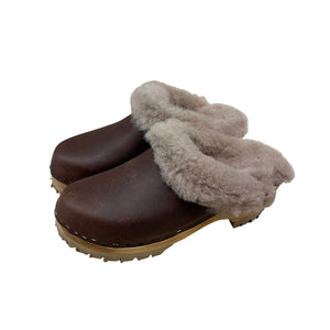 Pair of brown clogs with gray fur on a beige background