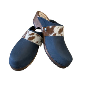 Pair of blue clogs with cowhide straps on a white surface