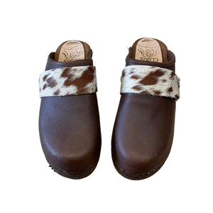 Pair of brown clogs with cowhide strap on a white background