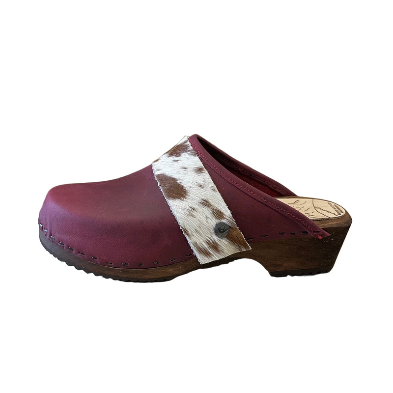 Maroon clog shoe with cowhide strap on a white background