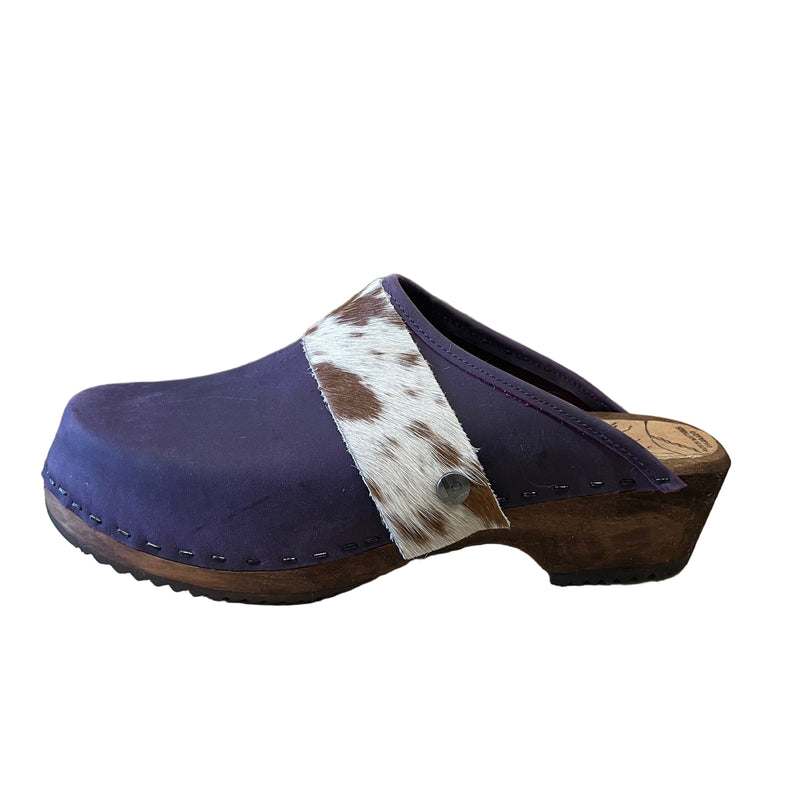 Purple clogs with cowhide straps on a white background