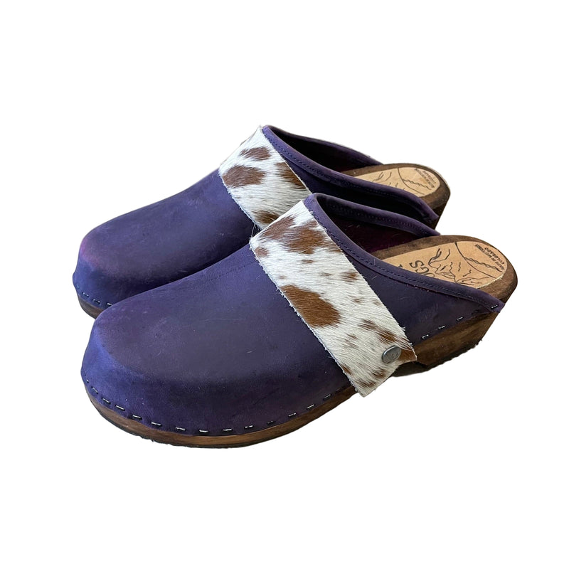 purple clogs with cowhide straps on a white background