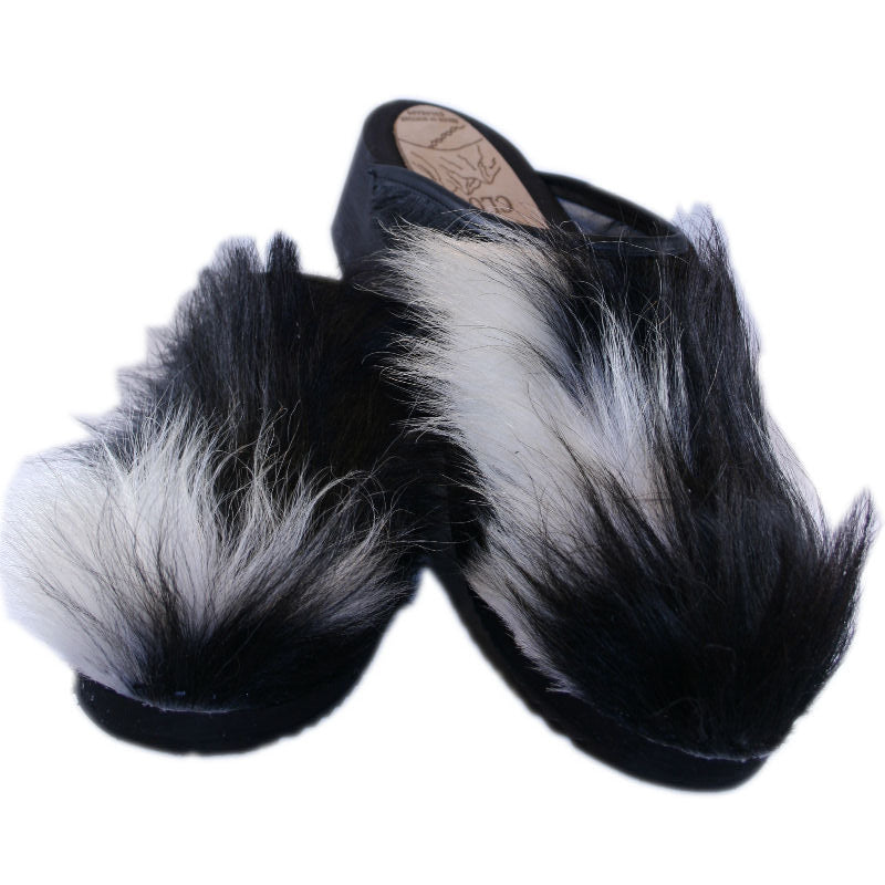 Extra Furry Black and White Cow Clogs on a wooden heel
